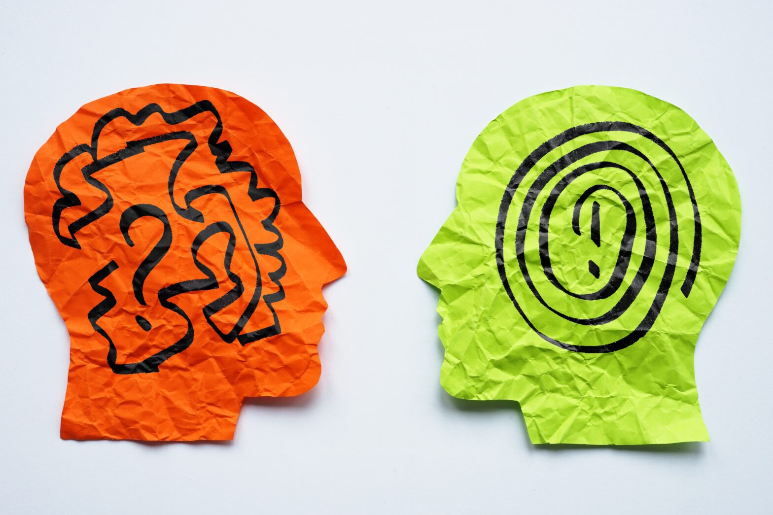 Paper heads with drawn lines as a concept for mentoring, teaching and psychotherapy.