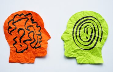 Paper heads with drawn lines as a concept for mentoring, teaching and psychotherapy.